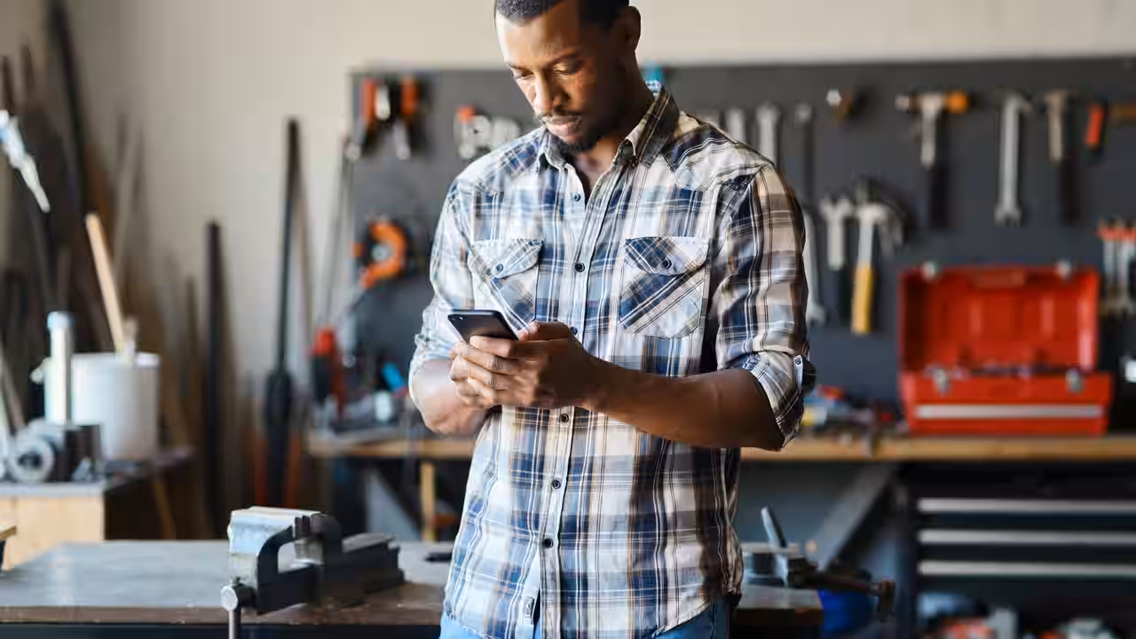 Handyman checking enquiries on his phone between jobs